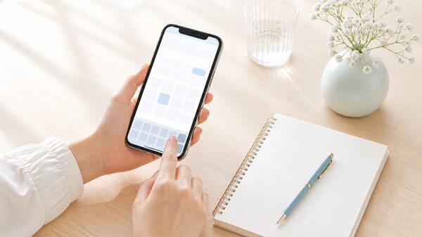 スマホで今の異体字の変換候補を確認している手元のイラスト
