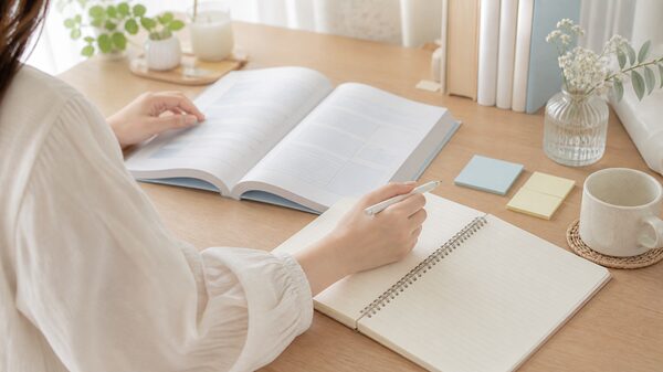 本とノートを見ながら漢字の読み方を確認している手元の画像